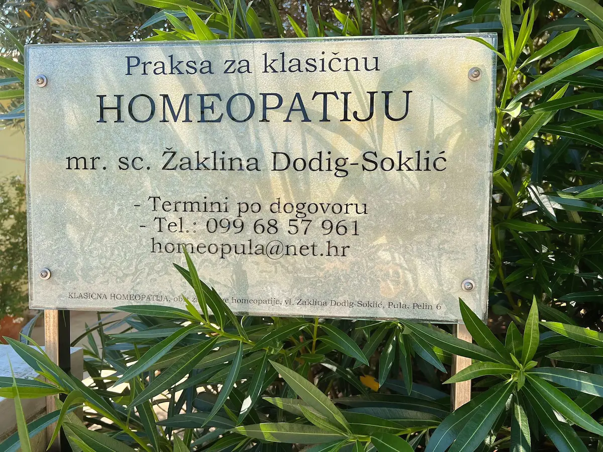 Službena ploča s natpisom i istaknutim akademskim kvalifikacijama ispred ordinacije za klasičnu homeopatiju u Puli.